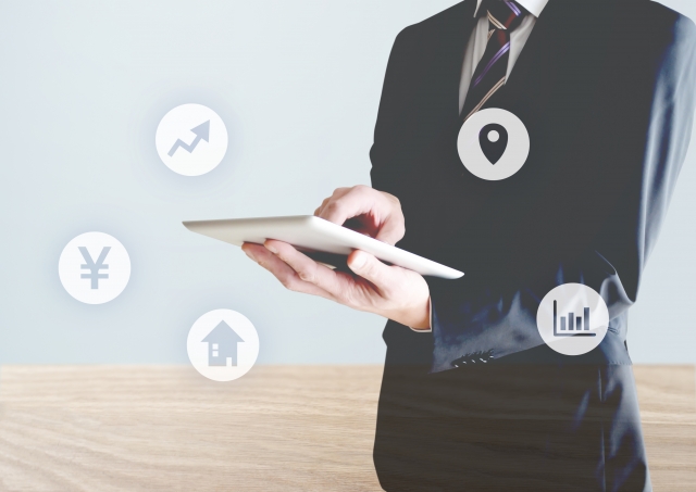 タブレットを持つスーツを着た男性